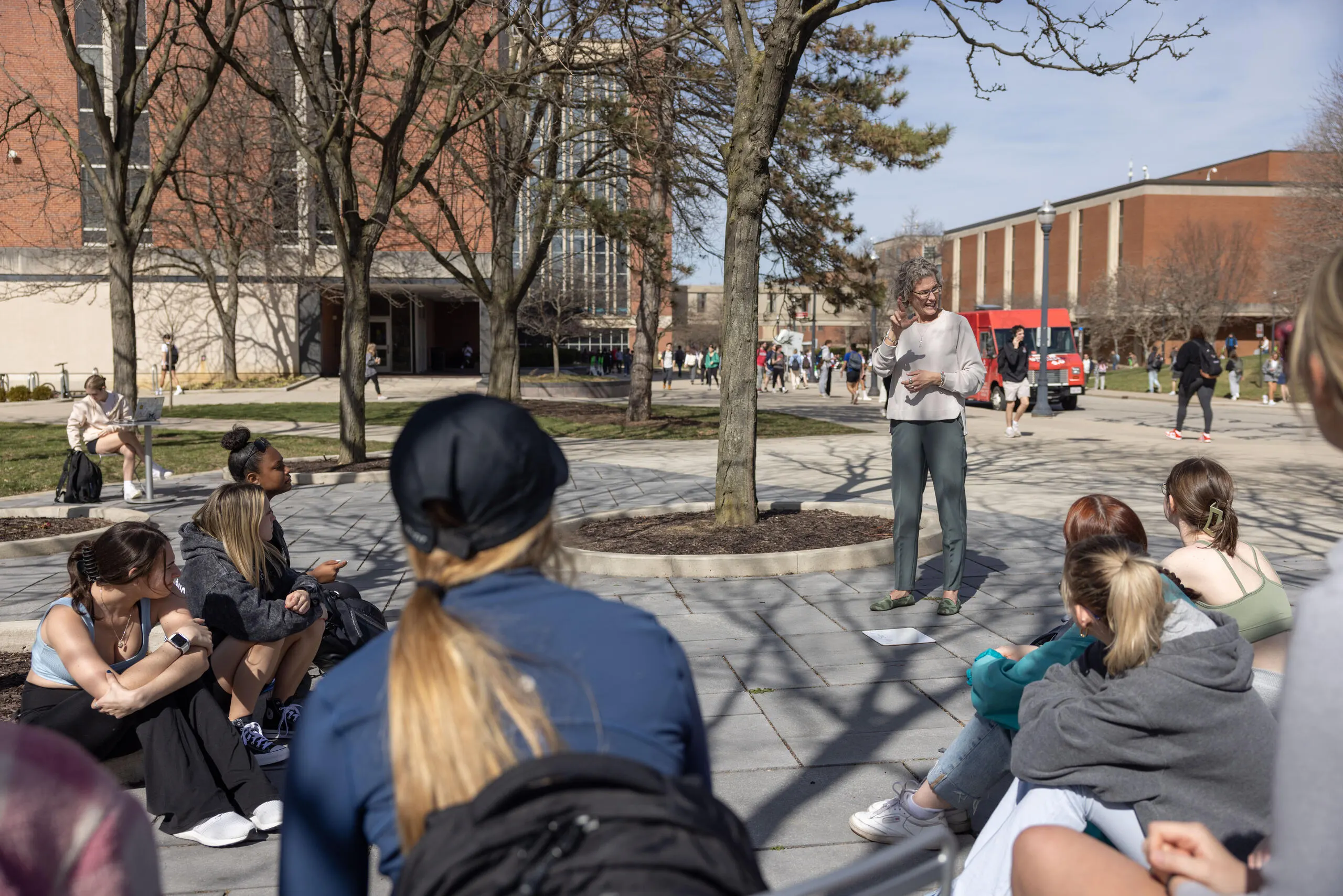 A professor teaching sign language outside on an early Spring day=