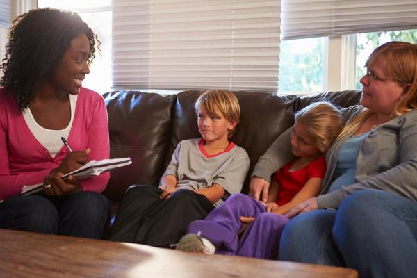 A social worker speaks to a family at home