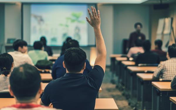 Student raising hand in classroom